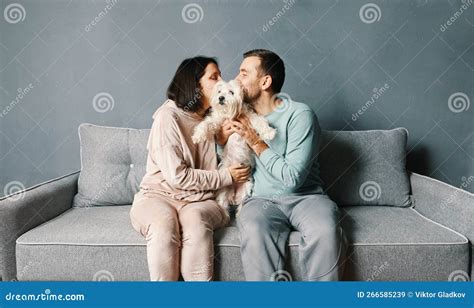 Casal Jovem Abraçando E Beijando Seu Cachorro Imagem de Stock Imagem