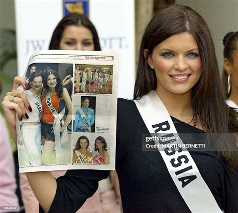 Miss Russia Kseniya Kustova shows a newspaper with pictures of her as ...