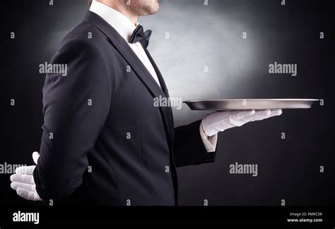 Waiter Holding Empty Silver Tray Over Black Background Stock Photo Alamy