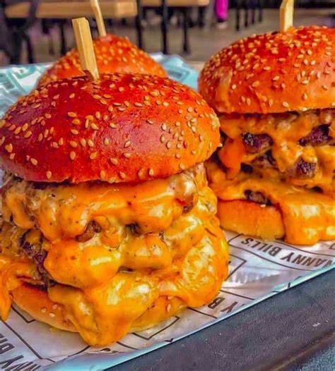 Two Cheeseburger Sandwiches With Toothpicks On Them Are Sitting On A Tray