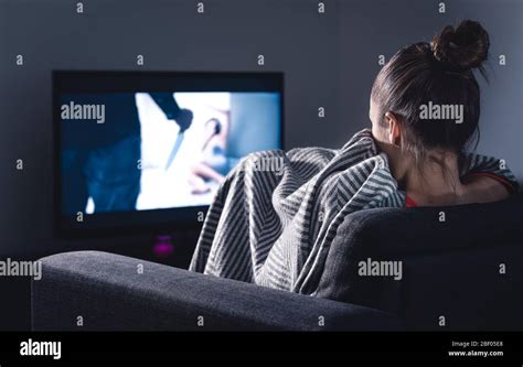 Película de terror en la televisión Mujer asustada viendo el servicio