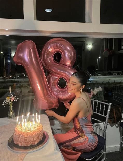 A Woman Sitting At A Table With A Birthday Cake And Large Number