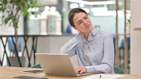 Tired Young Woman With Laptop Having Neck Pain In Office Stock Image