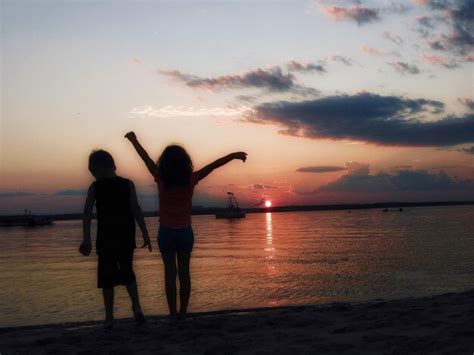 Premium Photo | Silhouette siblings standing at beach during sunset