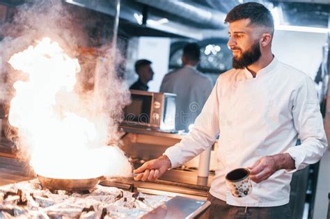 Frying Pan Is On Fire Chef In White Uniform Cooking Food At Kitchen Stock Image Image Of Food