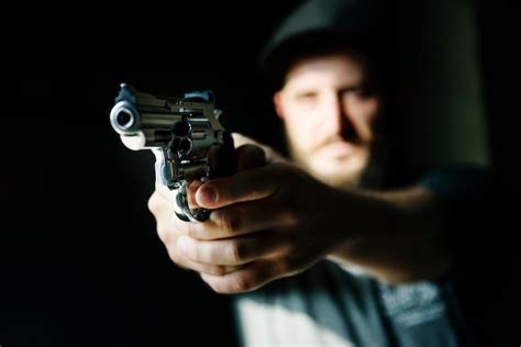 Homem Segurando Uma Arma Fundo Preto Foto Premium