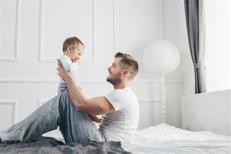 Premium Photo Happy Father With His Son Playing At Home On The Bed