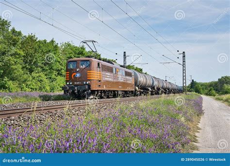 Bright Commuter Train Travelling Down The Railroad Tracks Editorial