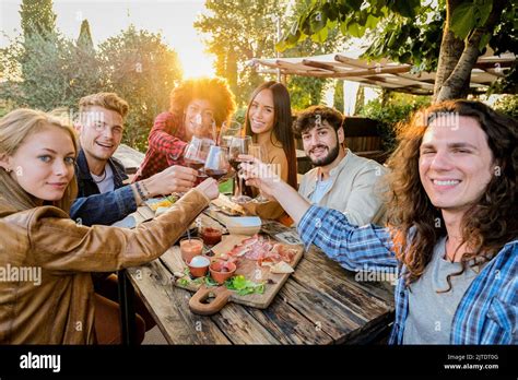 Group Of Multiracial Friends Taking Selfies And Celebrating With Wine