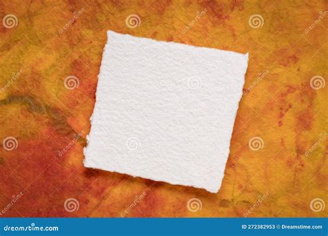 Small Square Sheet Of Blank White Paper Against Colorful Marbled Paper