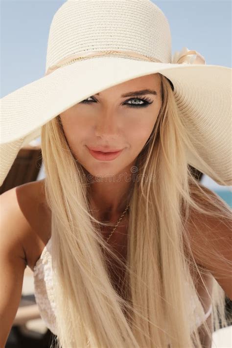 Woman With Blond Hair In Elegant Swimsuit And White Hat Stock Image