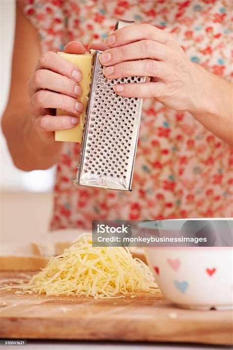 Close Up Of Woman Grating Cheese In Kitchen Stock Photo Download