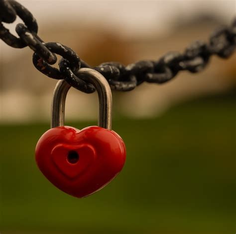 Premium Photo A Red Heart Shaped Padlock Hangs On A Chain A Symbol