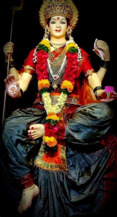 A Statue Of The Hindu Goddess Sitting On Top Of A Chair With Flowers In