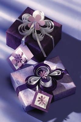 Two Gift Boxes With Ribbons And Bows On Them Are Sitting Side By Side