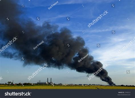 Huge Plume Of Black Smoke From Fire Rising High Above Flat Land Against Blue Sky Stock Photo ...