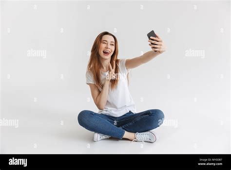 Portrait Of A Happy Young Girl Taking Selfie With Mobile Phone While