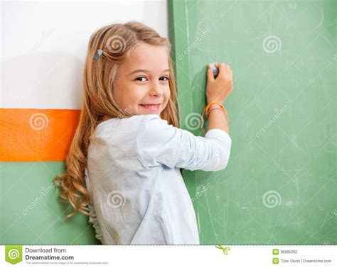 Girl Writing On Green Chalkboard In Classroom Stock Photo Image Of