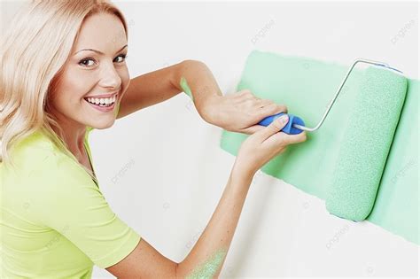 Smiling Young Woman Painting The Wall With Roller Brush Background And