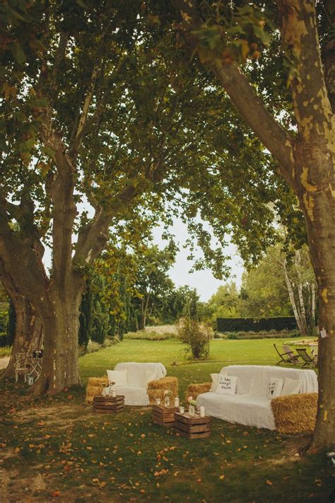 Two White Couches Sitting In The Middle Of A Lush Green Field Next To Trees