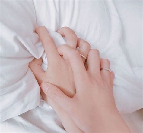 A Woman S Hand On Top Of A Pillow With Her Fingers Tucked Under The Covers