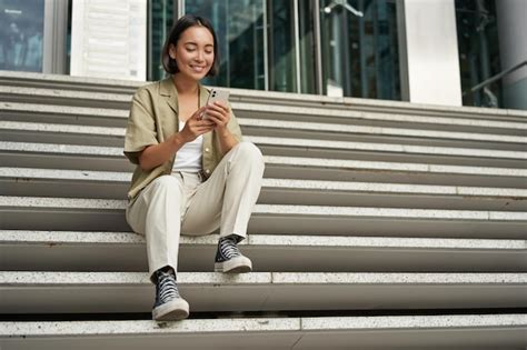 Tecnologia Celular E Pessoas Jovem Asiática Feliz Sentada Com