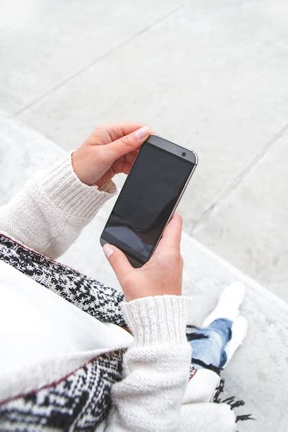 Premium Photo Young Woman Holding A Mobile Phone In Hands