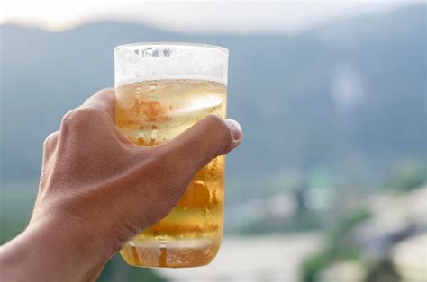 Premium Photo Close Up Of Hand Holding Glass Of Beer