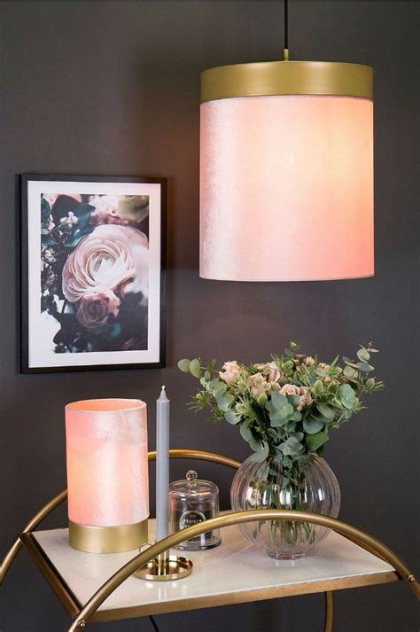 A Table Topped With A Vase Filled With Flowers Next To A Lamp