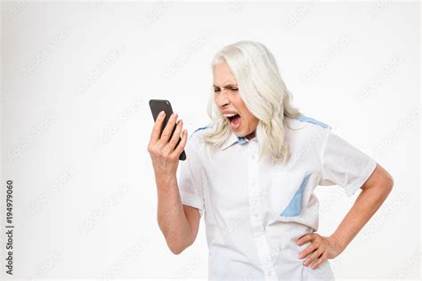 Portrait Of A Mad Mature Woman Yelling At Mobile Phone Stock Photo