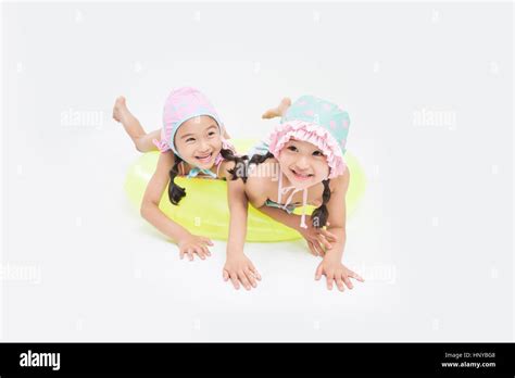 Smiling twin girls in swimsuits Stock Photo - Alamy