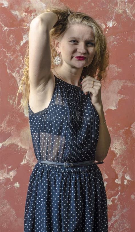 Jong Meisje Met Blonde Krullend Haar In Een Lange Kleding Met Stippen Met Teddybeer Stock Foto