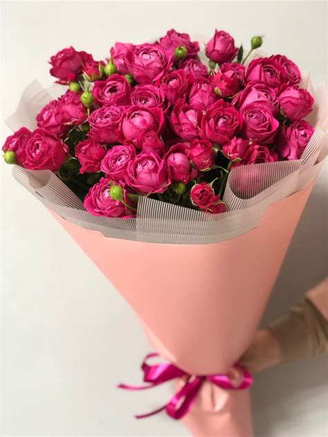 A Bouquet Of Pink Roses Wrapped In Paper