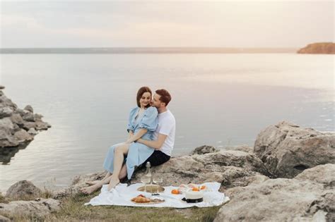 Premium Photo Couple Having A Picnic By The Lake