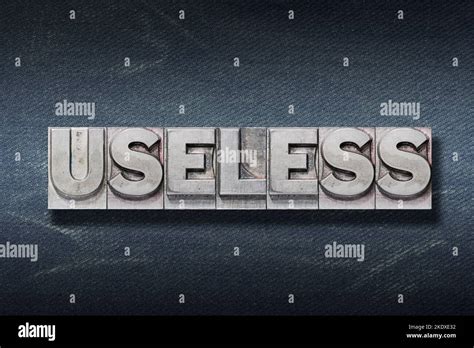 Useless Word Made From Metallic Letterpress On Dark Jeans Background