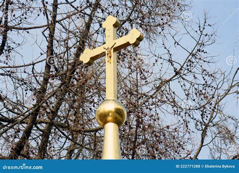 Golden Cross On The Church Roof Trees And Sky Background Stock Photo