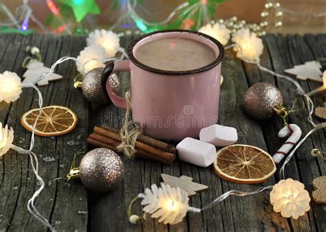 Pink Cup Of Hot Chocolate With Marshmallows On A Wooden Background Surrounded By Christmas Toys