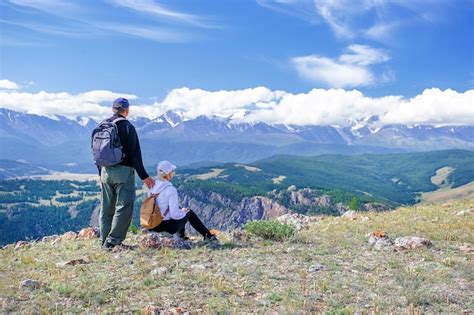 Premium Photo Couple Travelers Man And Woman Sitting On Cliff