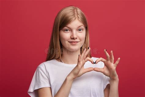 Amorous Lovely Cheerful Girl Showing Heart Gesture With Hands Stock