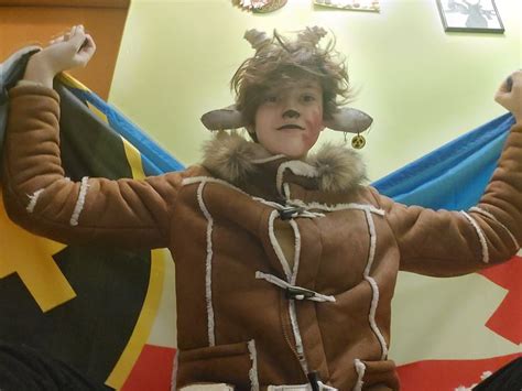 a person in a costume holding two flags and posing for the camera with their hands up