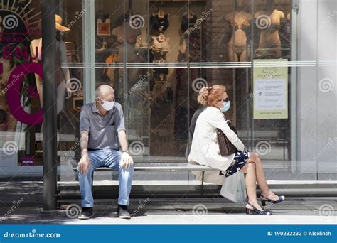 Two People Wearing Face Surgical Masks Waiting For The Public Transport