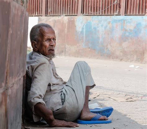 Premium Photo Side View Of Mature Man Sitting On Street Against Wall