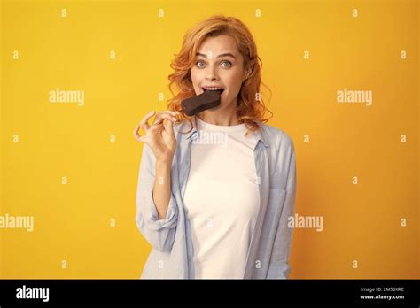 Portrait Of Redhead Girl With Chocolate Ice Cream On Yellow Background