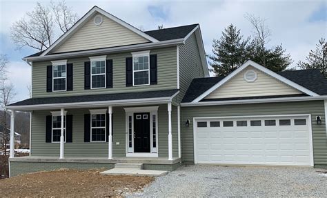 Beautiful craftsman style house with green siding and black shutters ...