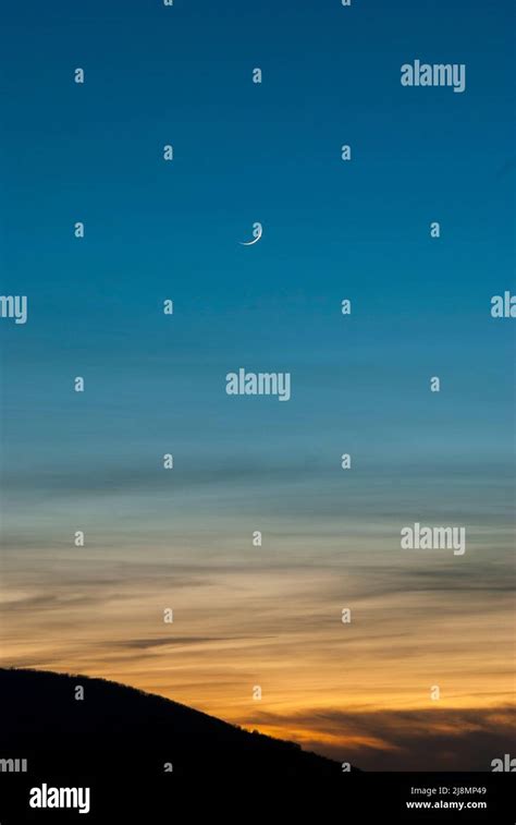Blue And Orange Sky Texture At Sunset In Vertical With Crescent Moon