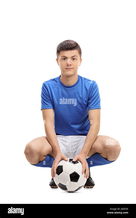 Teenage Soccer Player With A Football Looking At The Camera Isolated On