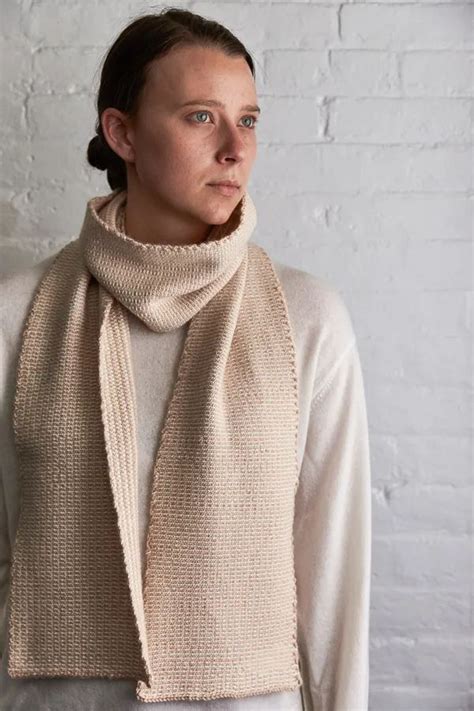 A Woman Wearing A Knitted Scarf In Beige