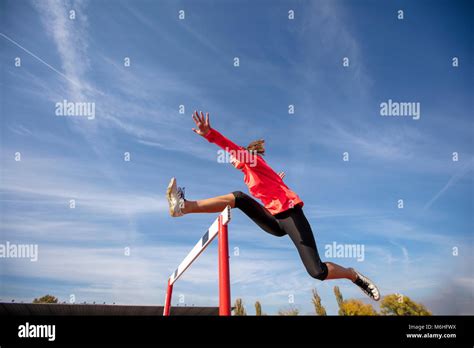 Female Athlete Jumping Above The Hurdle During The Race Stock Photo Alamy