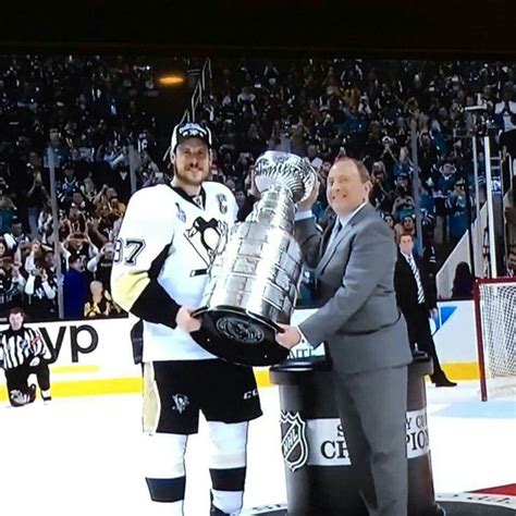 an ice hockey player is holding the stanleys cup and standing next to ...