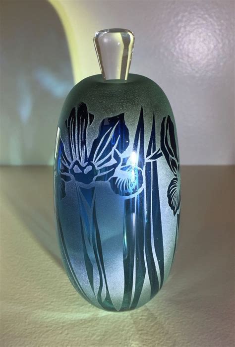 A Glass Vase Sitting On Top Of A Table Next To A White Wall And Floor